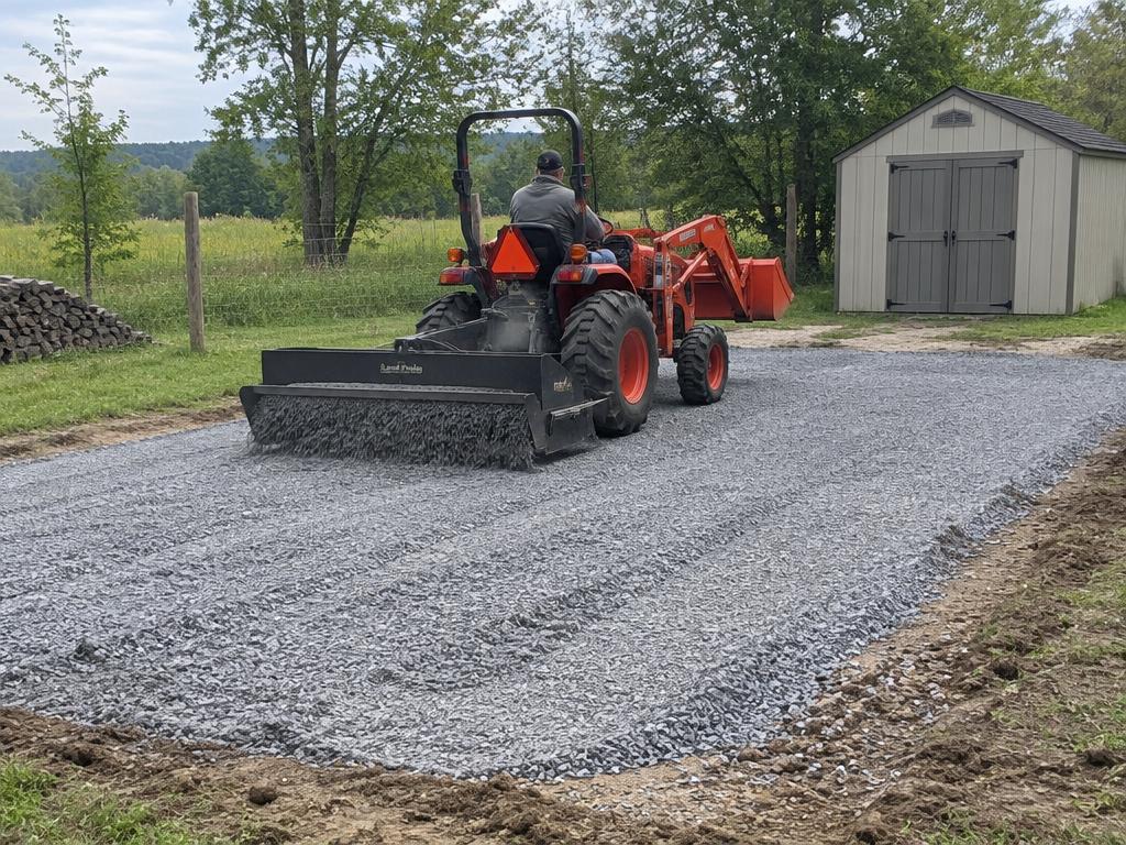 Tractor leveling a gravel pad for a storage shed